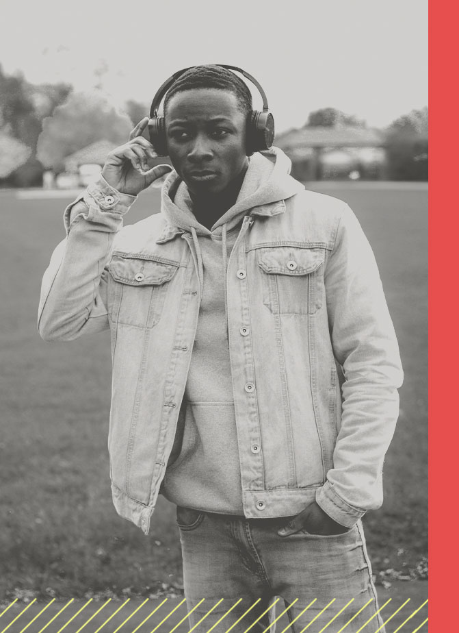 Young man wearing headphones in a field