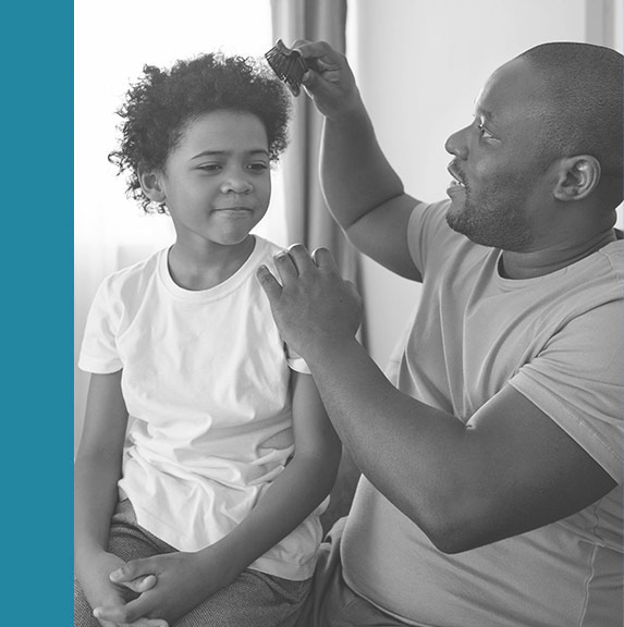 Photo of dad combing daughter's hair